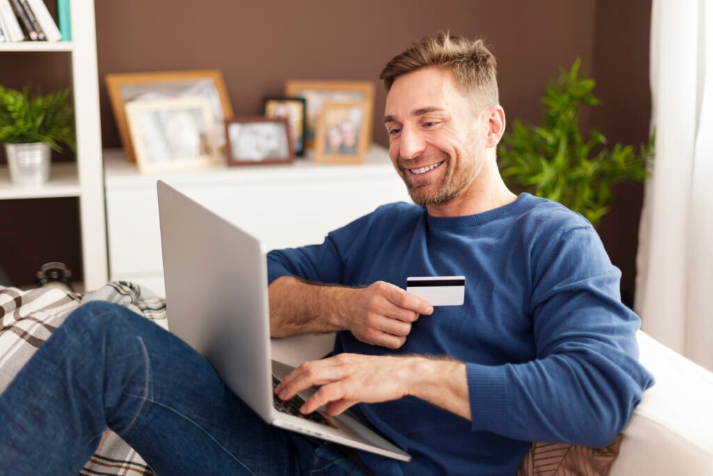 smiling man during online shopping at home